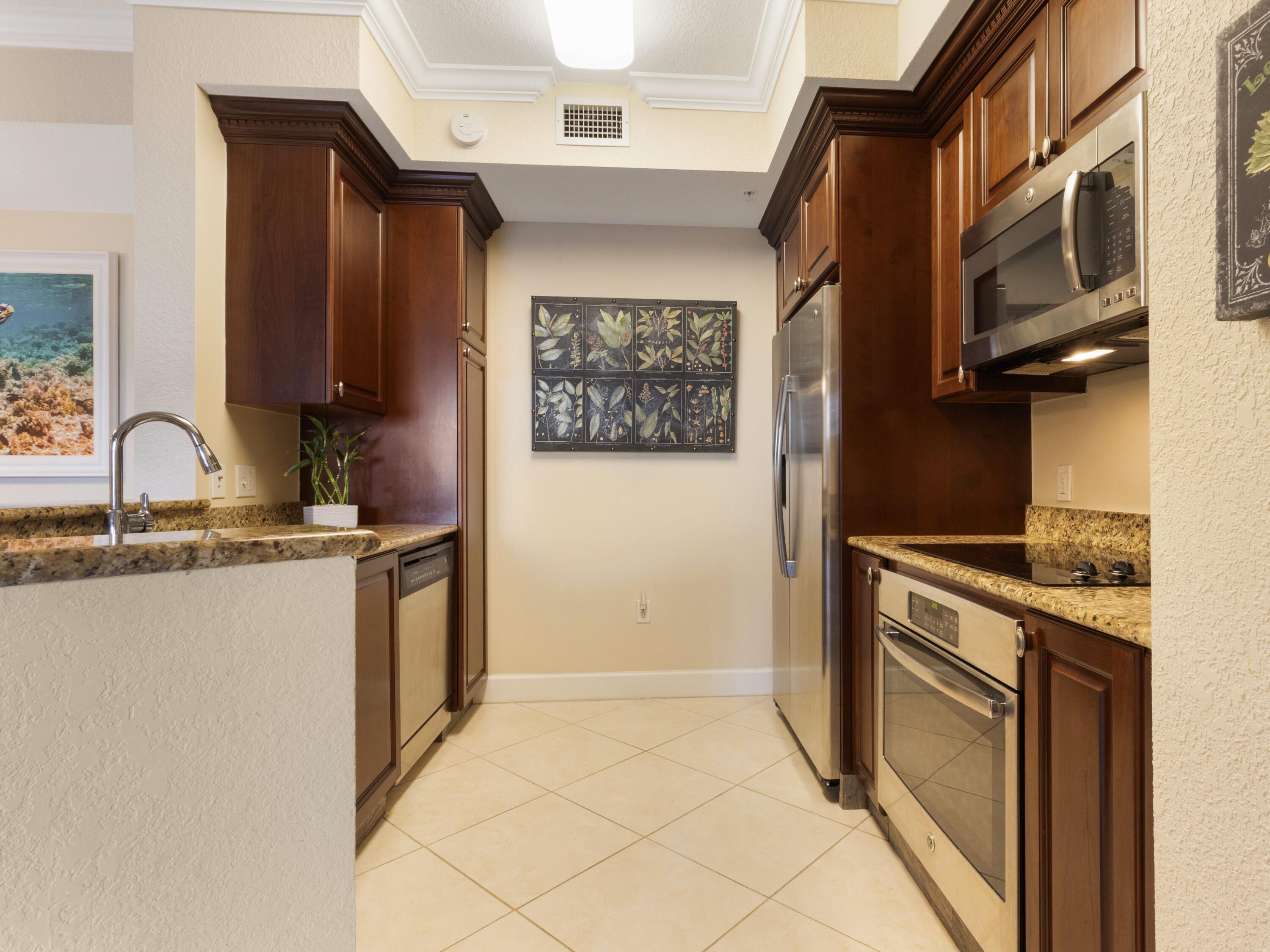 1690 Renaissance Commons Boulevard, Unit 1412 Boynton Beach, FL 33426 - Photo 4 of 49 a kitchen with stainless steel appliances granite countertop a stove and a sink