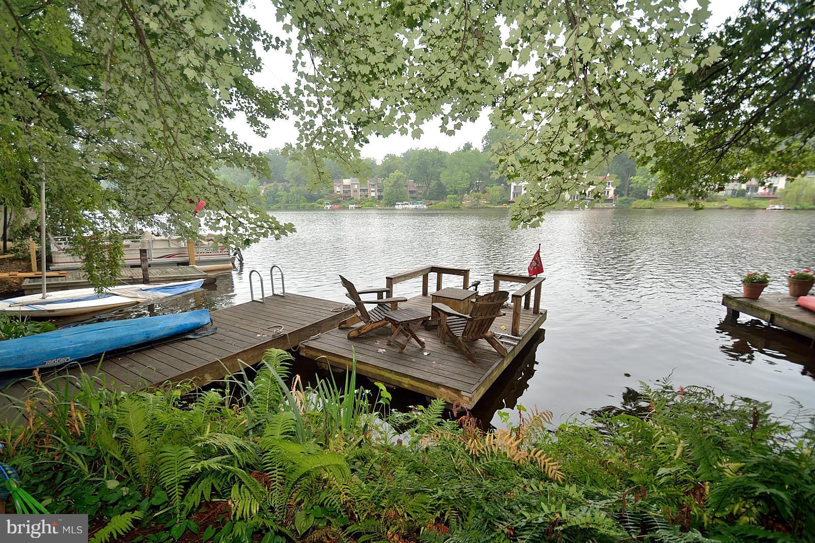 1608 Waters Edge Lane Reston, VA 20190 - Photo 26 of 27 a view of a lake with lawn chairs and a large tree
