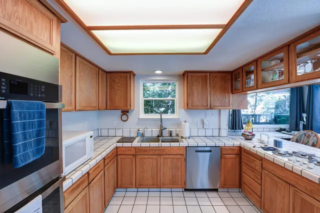 a kitchen with stainless steel appliances a refrigerator and a view of living room