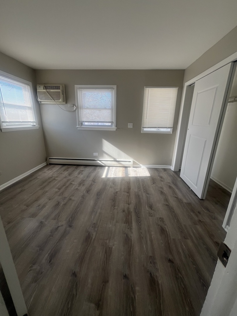 1340 North Main Street, Unit E4 Wheaton, IL 60187 - Photo 3 of 7 wooden floor in an empty room with a window