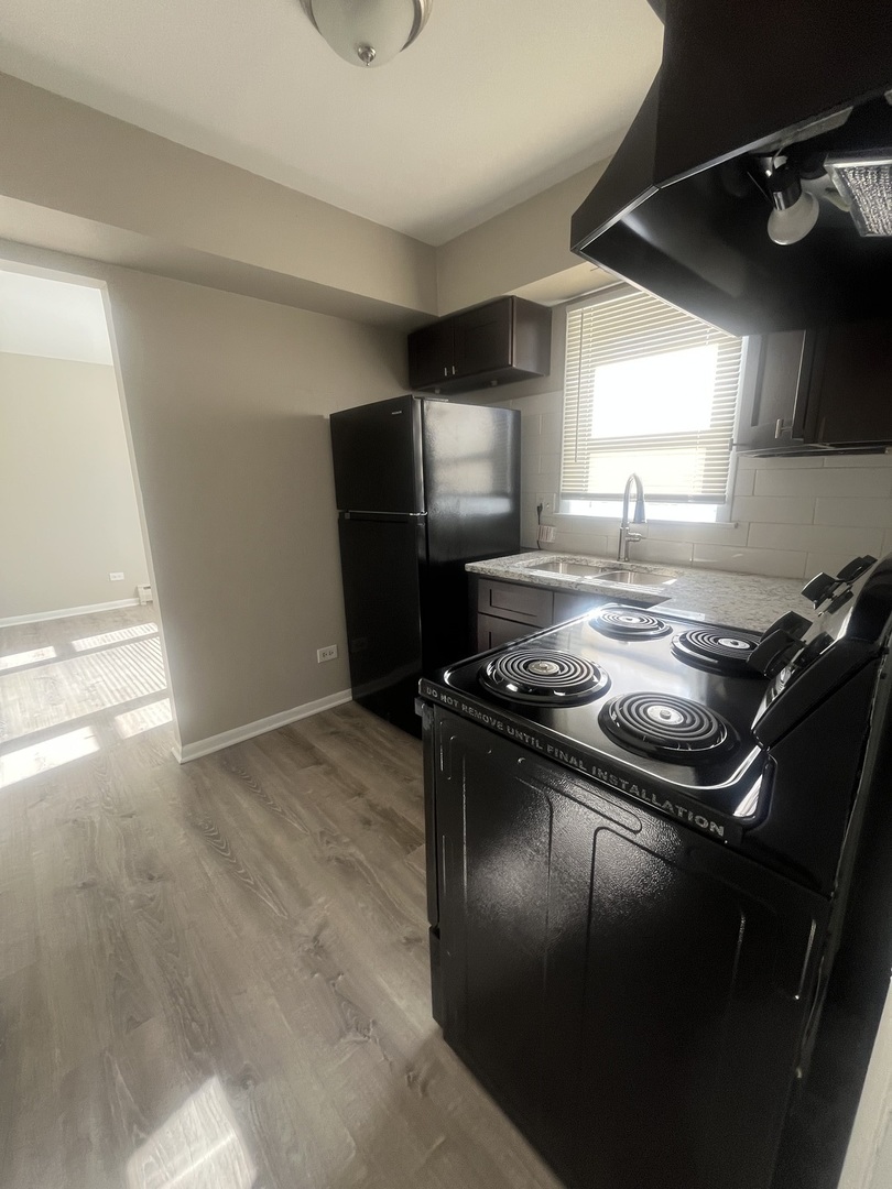 1340 North Main Street, Unit E4 Wheaton, IL 60187 - Photo 4 of 7 a kitchen with a stove and a refrigerator