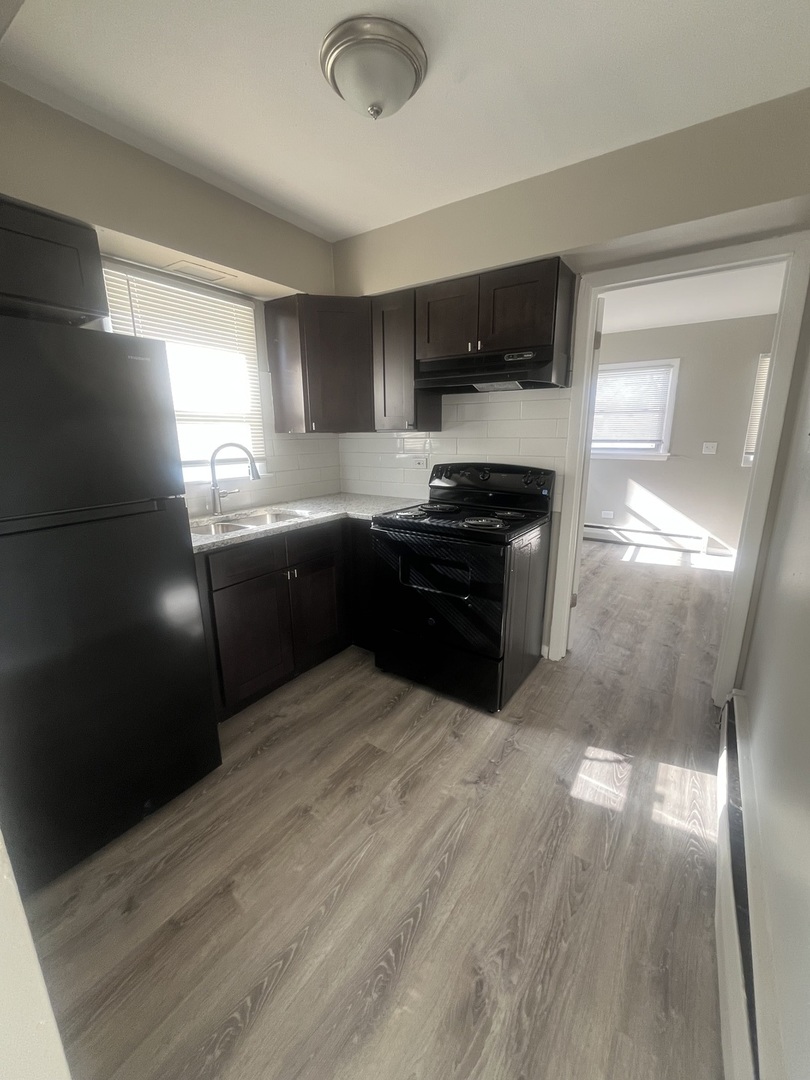 1340 North Main Street, Unit E4 Wheaton, IL 60187 - Photo 5 of 7 a kitchen with stainless steel appliances granite countertop a stove a sink and a refrigerator
