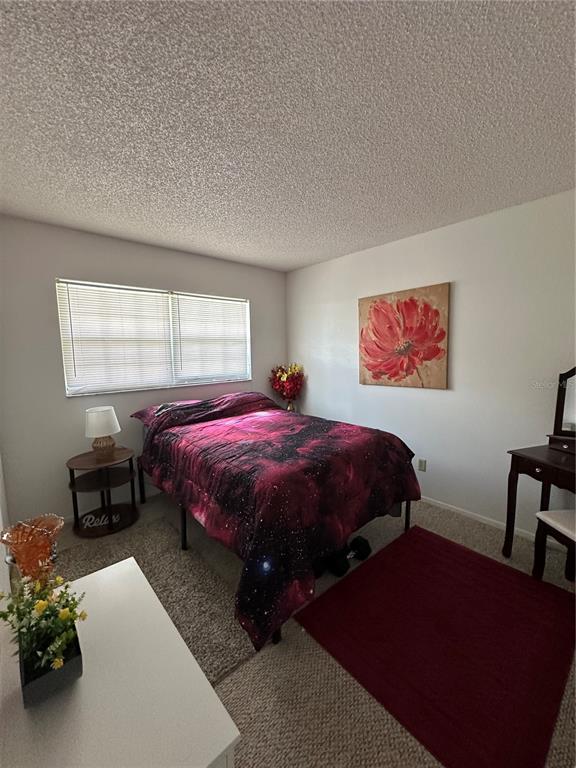 584 Fairways Lane, Unit F202 Ocala, FL 34472 - Photo 14 of 17 a spacious bedroom with a bed dresser and a window