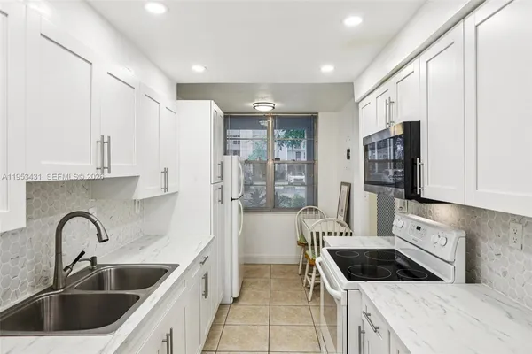 a kitchen with a sink cabinets a refrigerator and a sink
