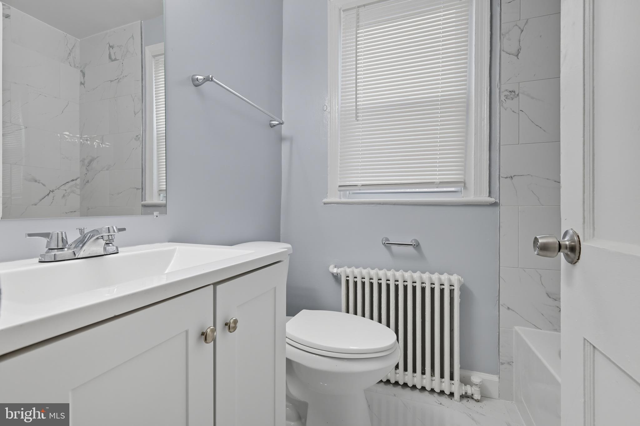3919 R Street Southeast, Unit 2 Washington, DC 20020 - Photo 25 of 41 a bathroom with a sink a toilet and a mirror