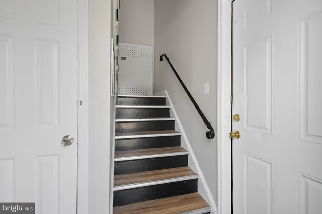 a view of staircase with wooden floor and white walls