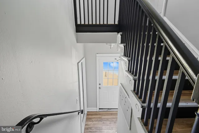 a view of staircase with railing and white walls