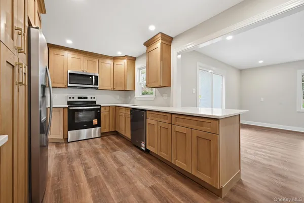 a kitchen with stainless steel appliances granite countertop a stove a sink and a refrigerator