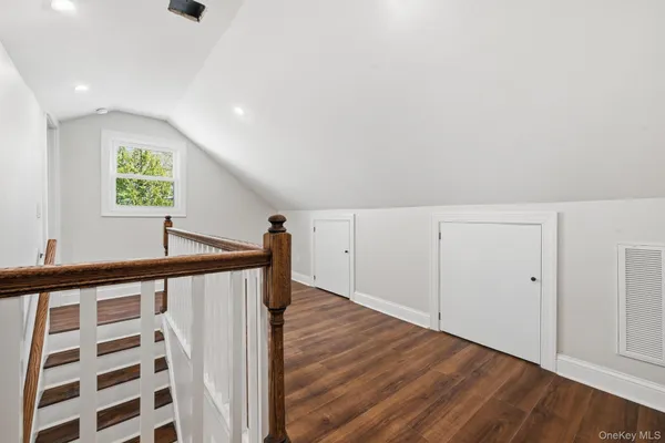 a view of a hallway with wooden floor and a window