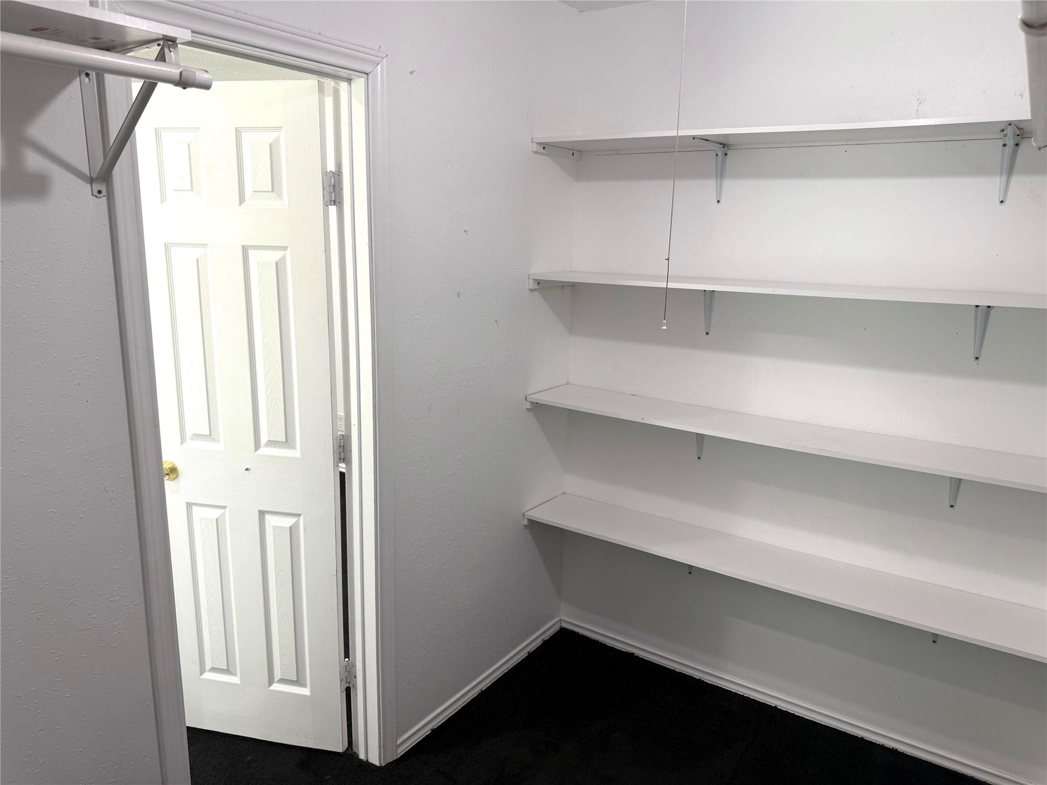 9822 Candy Court, Unit B Spring, TX 77379 - Photo 11 of 27 a view of walk in closet with empty racks