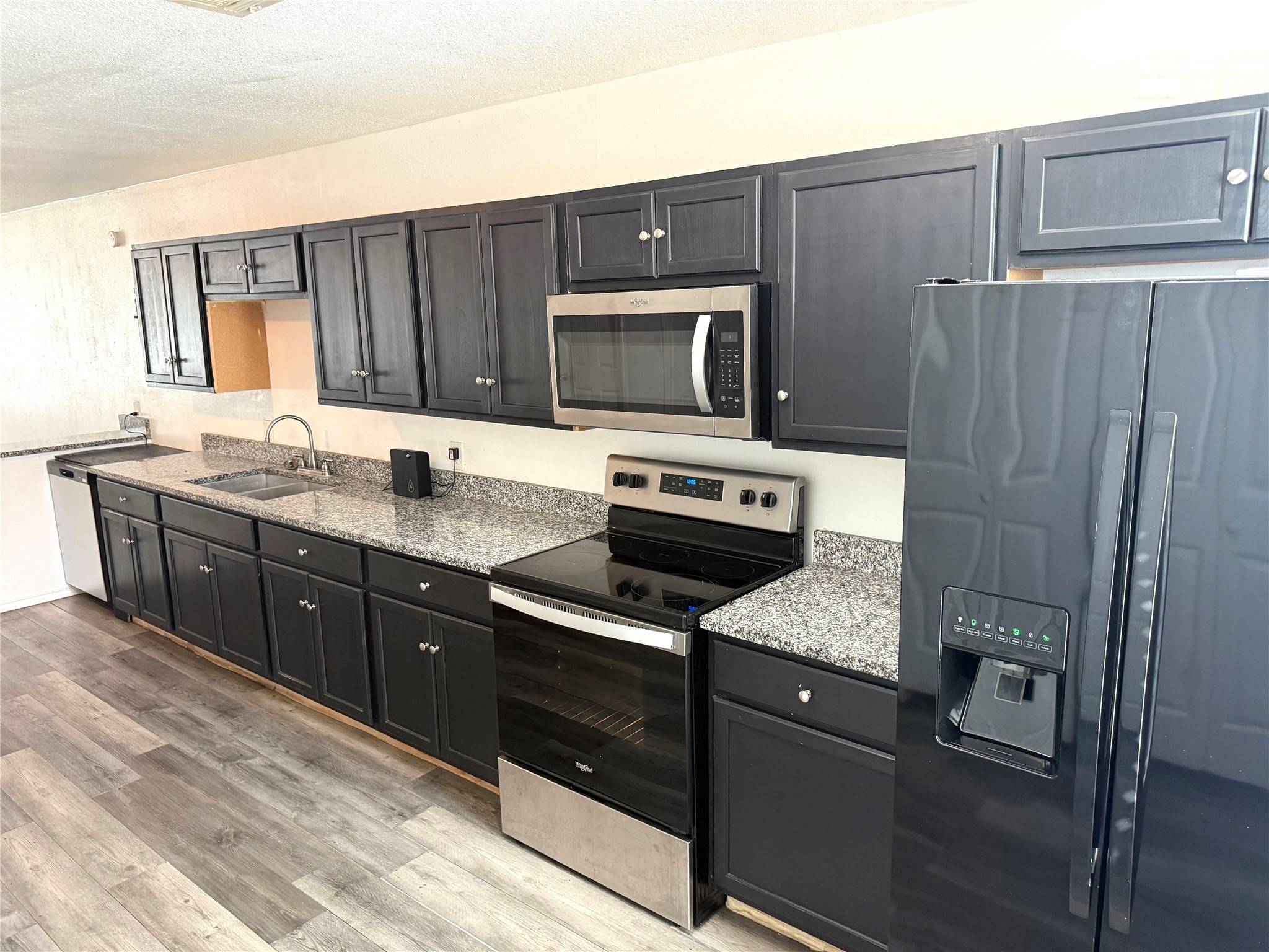 9822 Candy Court, Unit B Spring, TX 77379 - Photo 17 of 27 a kitchen with stainless steel appliances granite countertop a stove microwave and refrigerator