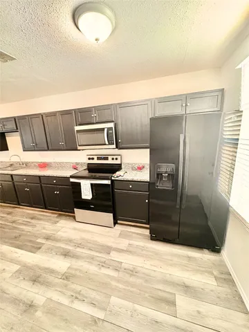 a kitchen with stainless steel appliances granite countertop a sink dishwasher stove and refrigerator