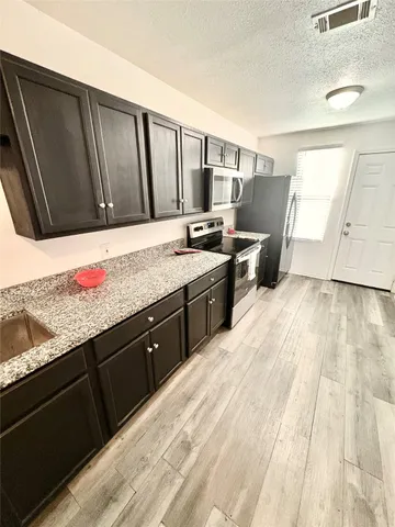 a large bedroom with a bed and cabinets