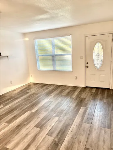 a view of a room with wooden floor and window
