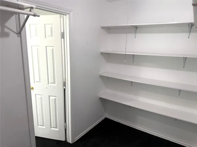 a view of walk in closet with empty racks