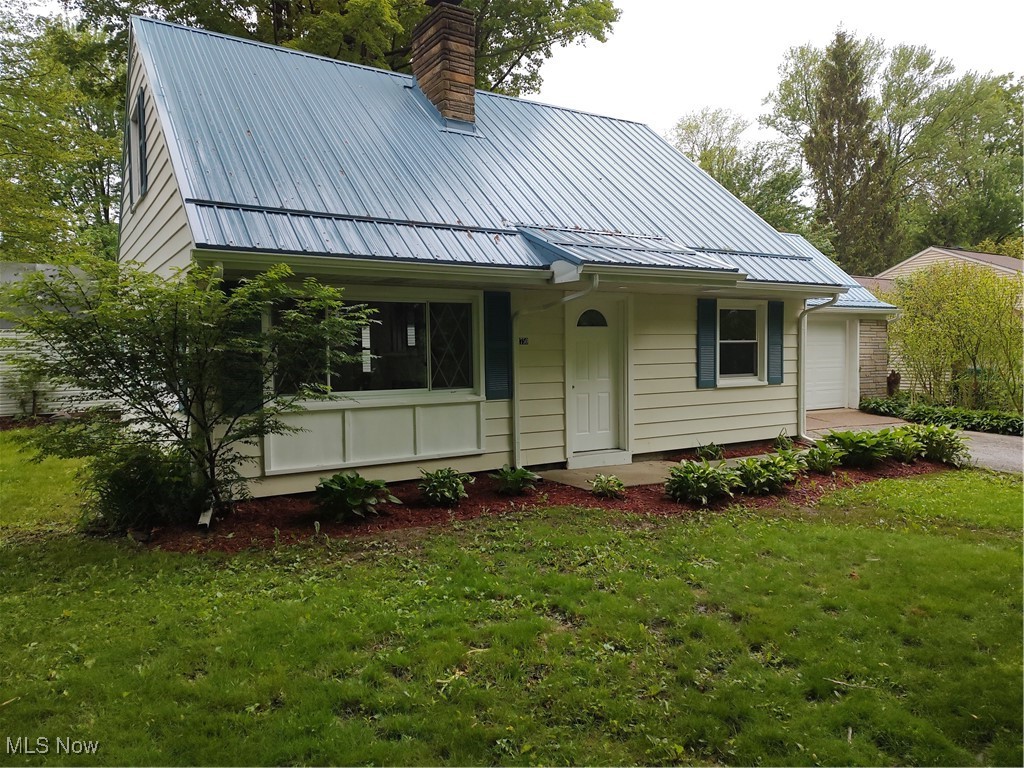 1750 Trinity Road Madison, OH 44057 - Photo 4 of 28 View of front of home with a chimney, metal roof, a front yard, and a garage