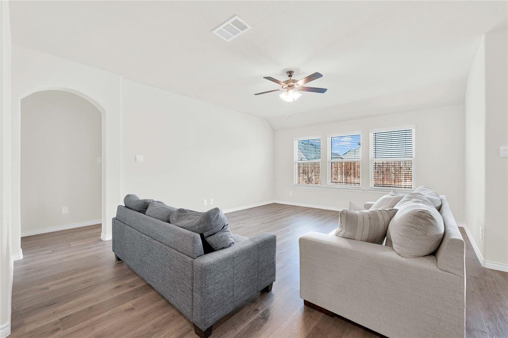 9713 Quail Pointe Road Aubrey, TX 76227 - Photo 12 of 23 Living area featuring arched walkways, wood finished floors, and a ceiling fan