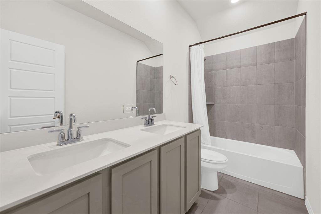 9713 Quail Pointe Road Aubrey, TX 76227 - Photo 3 of 23 Full bath with double vanity, shower / bathtub combination with curtain, and light tile patterned floors