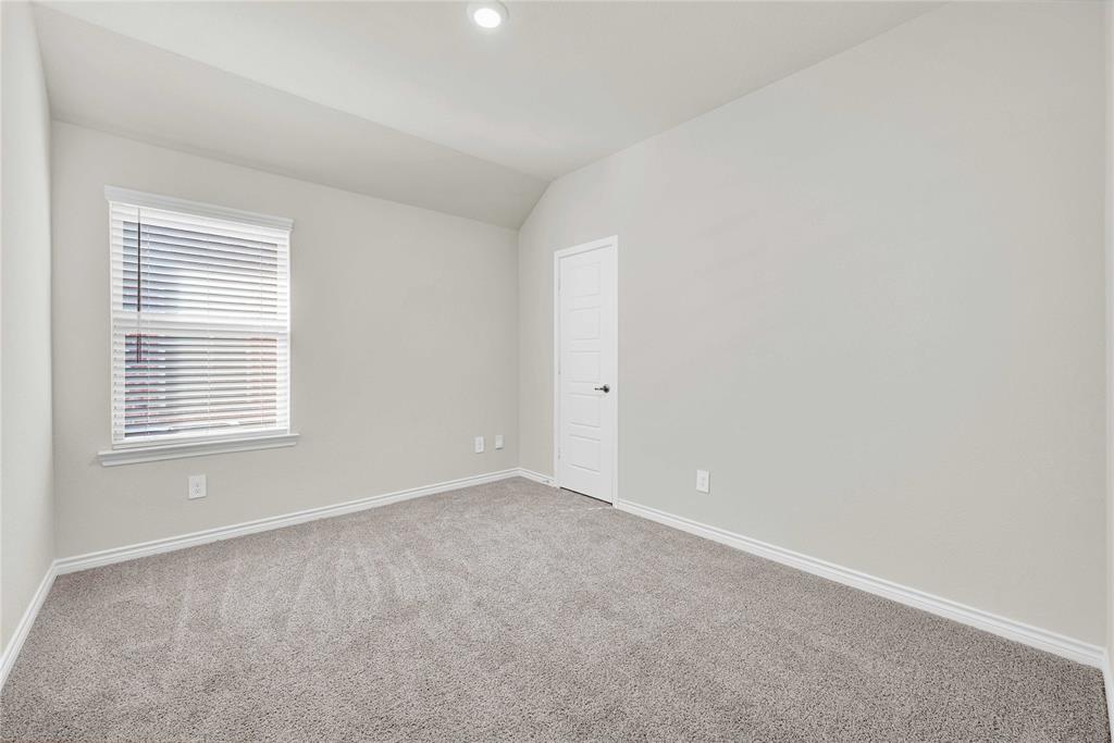 9713 Quail Pointe Road Aubrey, TX 76227 - Photo 5 of 23 Carpeted empty room featuring baseboards and vaulted ceiling
