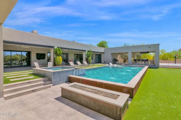 a bedroom with a bed and a lamp on the dresser