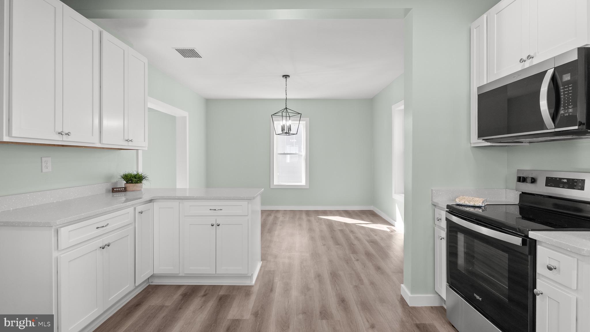 603 East Chestnut Street Delmar, MD 21875 - Photo 10 of 33 a kitchen with white cabinets stainless steel appliances and wooden floor