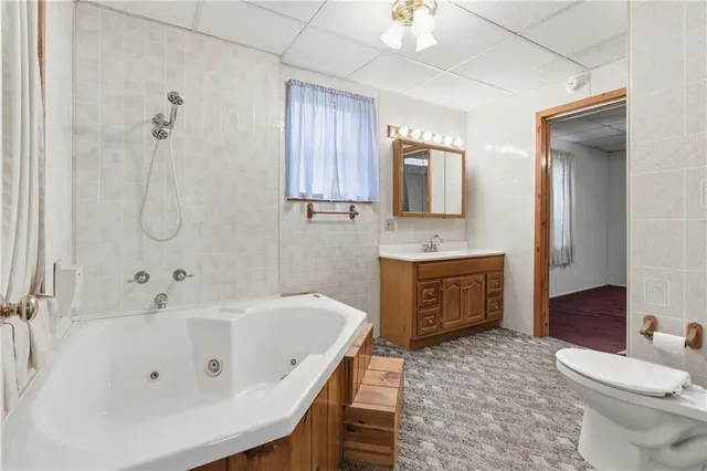 a bathroom with a tub sink and toilet