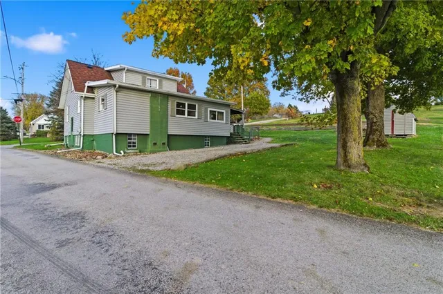 a view of a house with a big yard and large trees