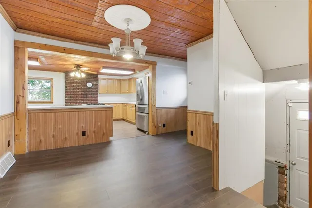 a view of a hallway with wooden floor and chandelier