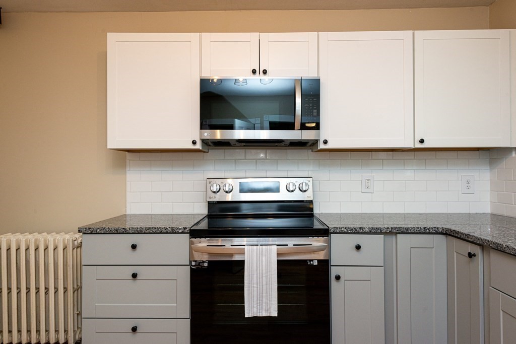 13 Melville Place Lynn, MA 01902 - Photo 8 of 41 a kitchen with stainless steel appliances granite countertop a sink and a microwave