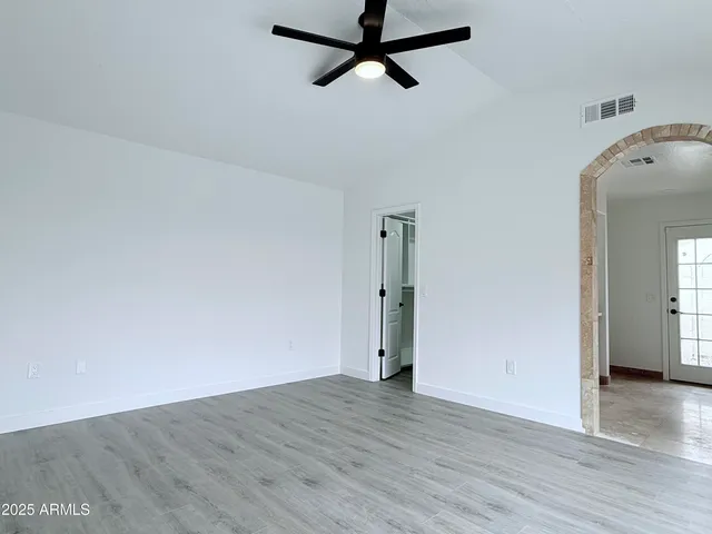 a view of a room with wooden floor and a ceiling fan
