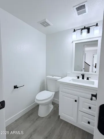 a bathroom with a sink mirror and toilet