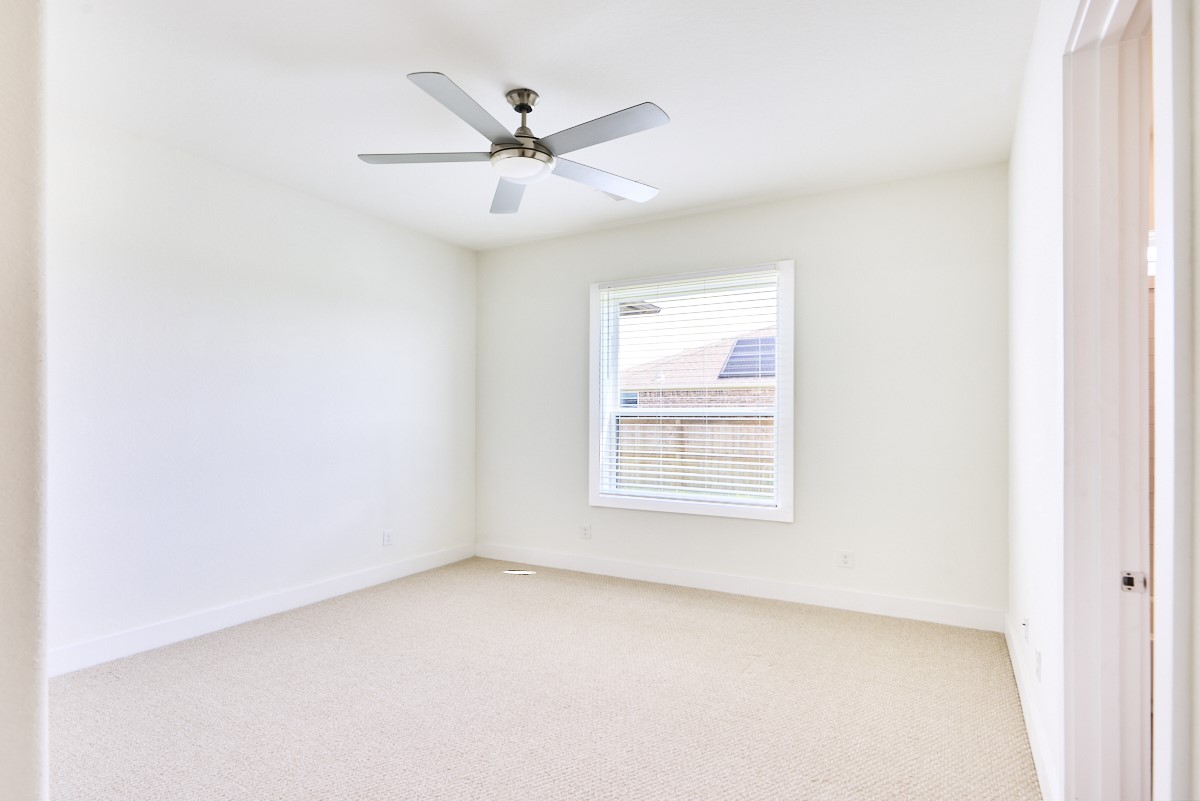 7911 Stratford Hall Drive Rosharon, TX 77583 - Photo 24 of 34 an empty room with a window and a fan