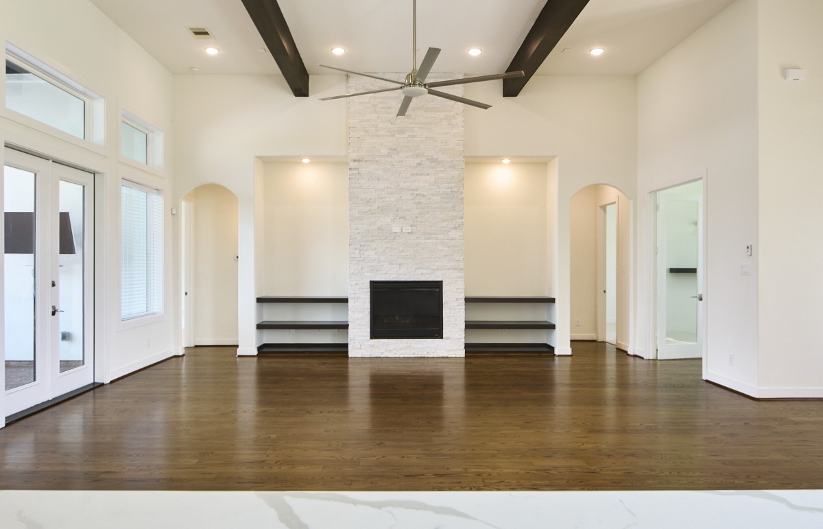 7911 Stratford Hall Drive Rosharon, TX 77583 - Photo 3 of 34 an empty room with wooden floor fireplace and staircase