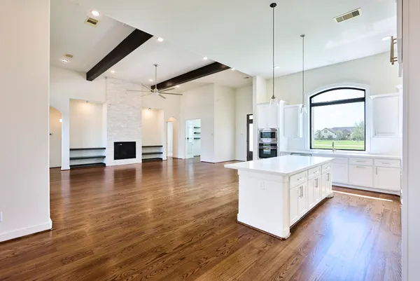 a large kitchen with a lot of counter space and wooden floor