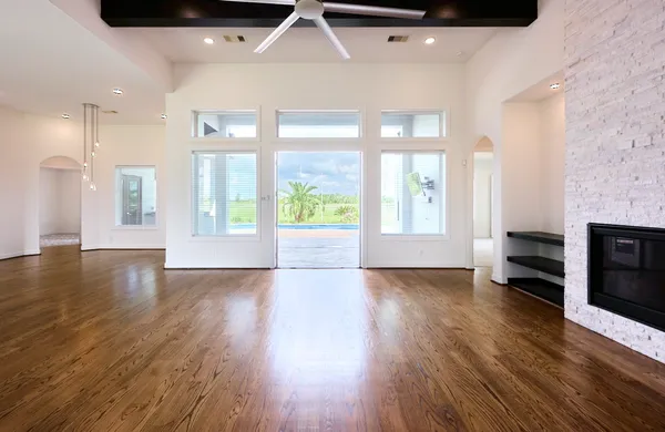 a kitchen with kitchen island granite countertop a stove a sink a refrigerator and white cabinets with wooden floor