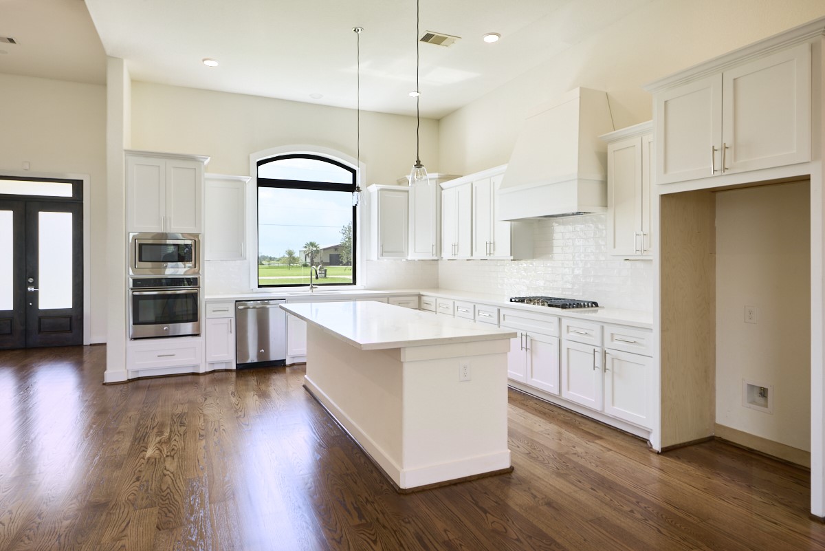 7911 Stratford Hall Drive Rosharon, TX 77583 - Photo 7 of 34 a kitchen with kitchen island granite countertop a stove a sink a refrigerator and white cabinets with wooden floor