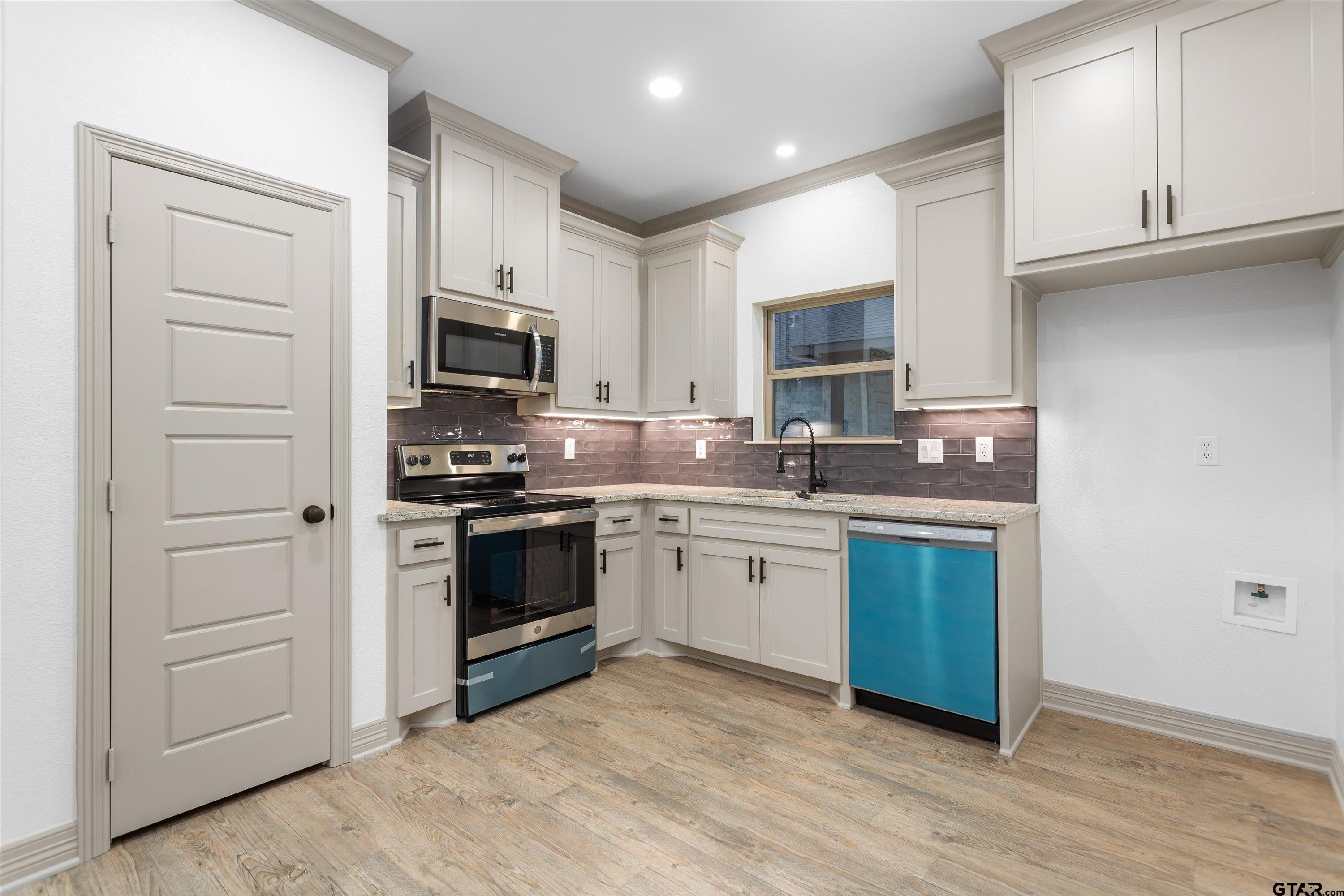 927 Nell Avenue Tyler, TX 75701 - Photo 12 of 20 a kitchen with granite countertop a stove and a sink
