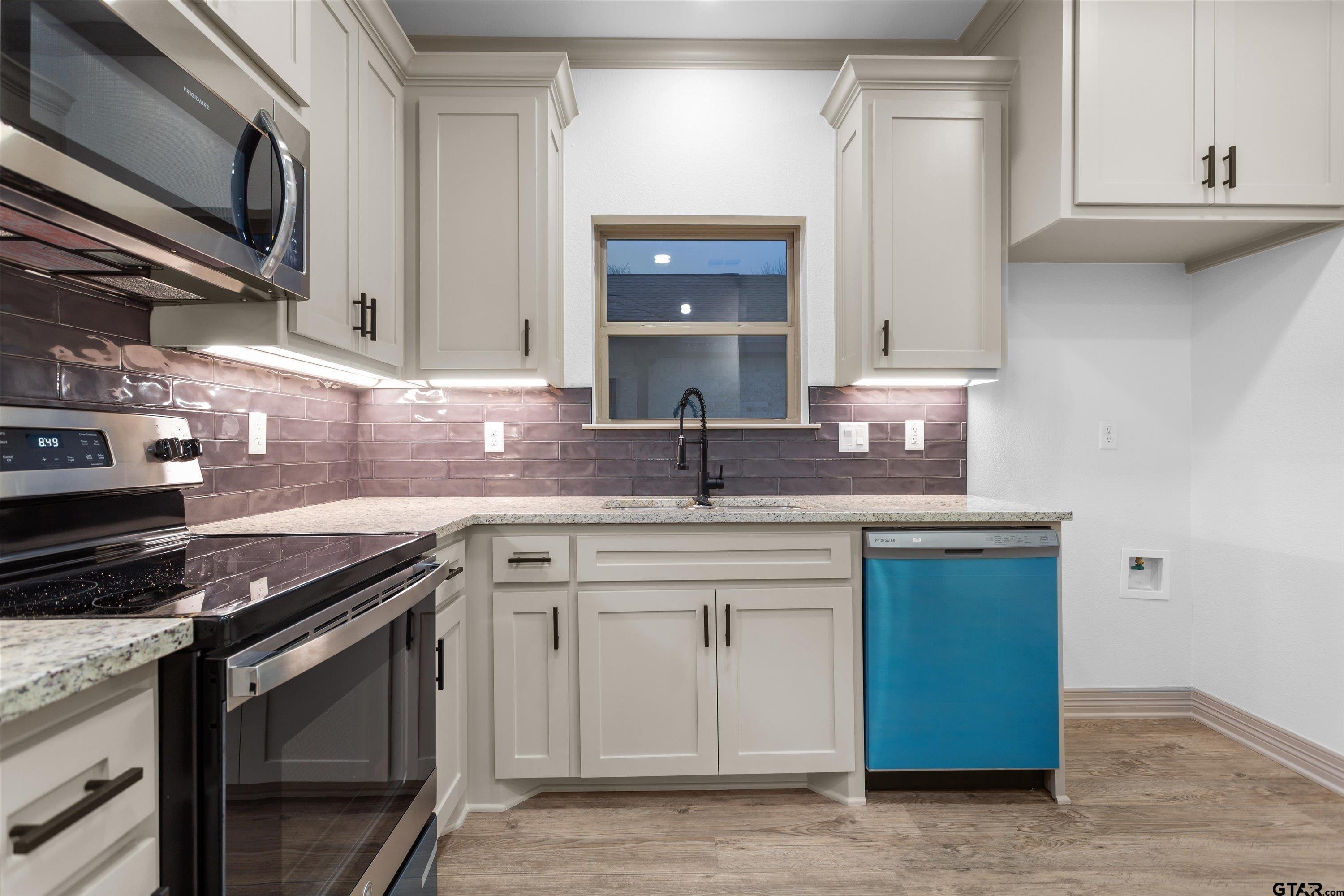 927 Nell Avenue Tyler, TX 75701 - Photo 13 of 20 a kitchen with granite countertop a sink stainless steel appliances and cabinets