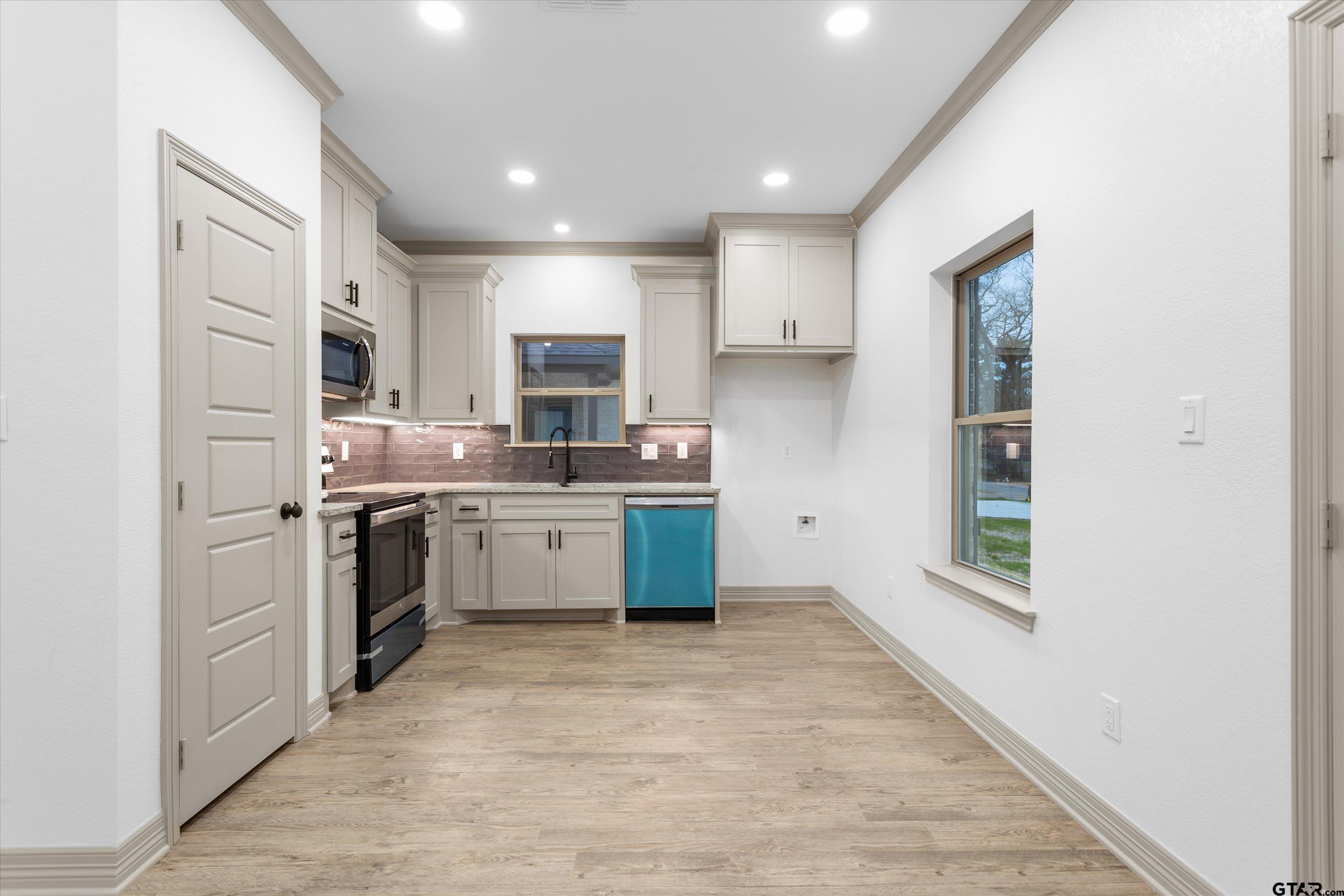 927 Nell Avenue Tyler, TX 75701 - Photo 14 of 20 a kitchen with a sink cabinets stainless steel appliances and a window