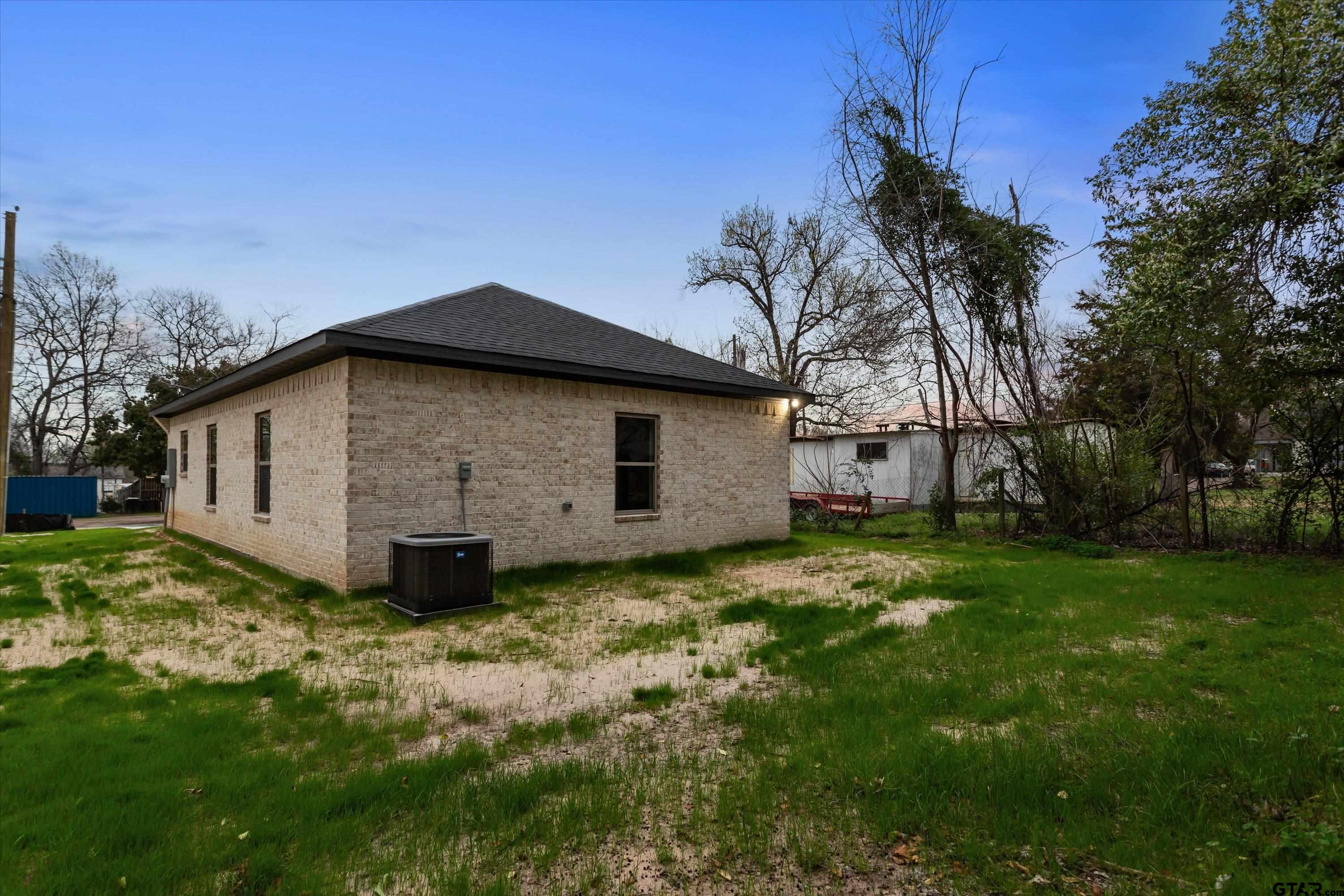 927 Nell Avenue Tyler, TX 75701 - Photo 6 of 20 a view of a backyard with potted plants and large tree