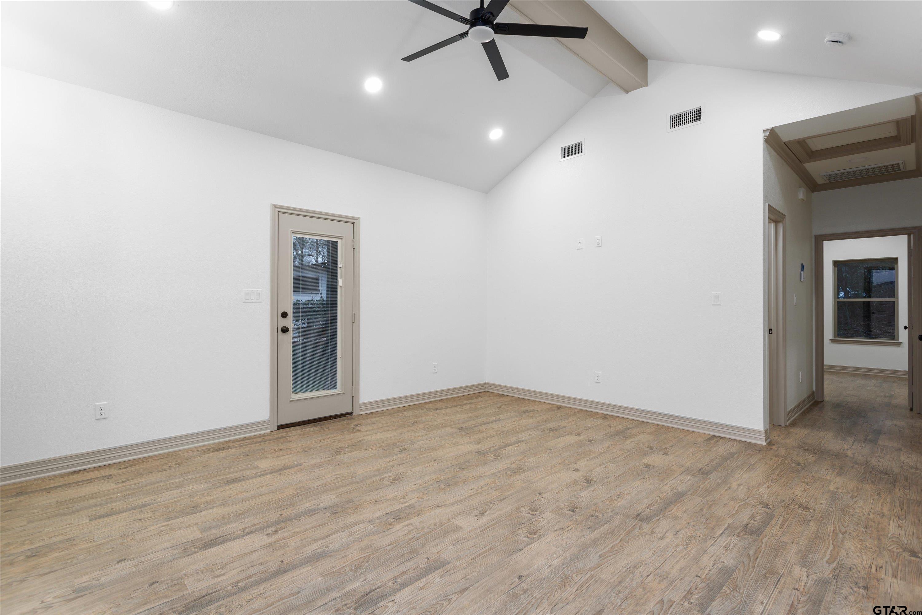 927 Nell Avenue Tyler, TX 75701 - Photo 10 of 20 an empty room with wooden floor and a ceiling fan