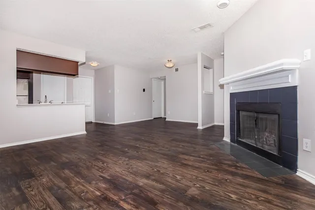 a view of a livingroom with wooden floor and a fireplace