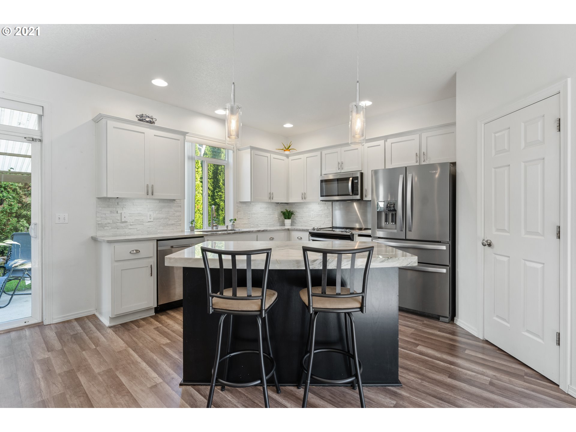 3122 South 2nd Street Ridgefield, WA 98642 - Photo 7 of 30 a kitchen with stainless steel appliances kitchen island granite countertop a table chairs stove microwave and cabinets