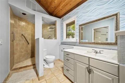 a bathroom with a granite countertop sink toilet and shower