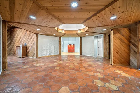 a view of an empty room with a fireplace and windows