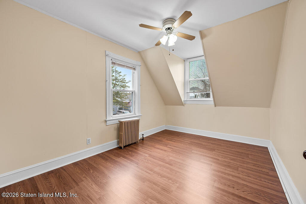 5272 Arthur Kill Road Staten Island, NY 10307 - Photo 18 of 32 an empty room with wooden floor fan and windows