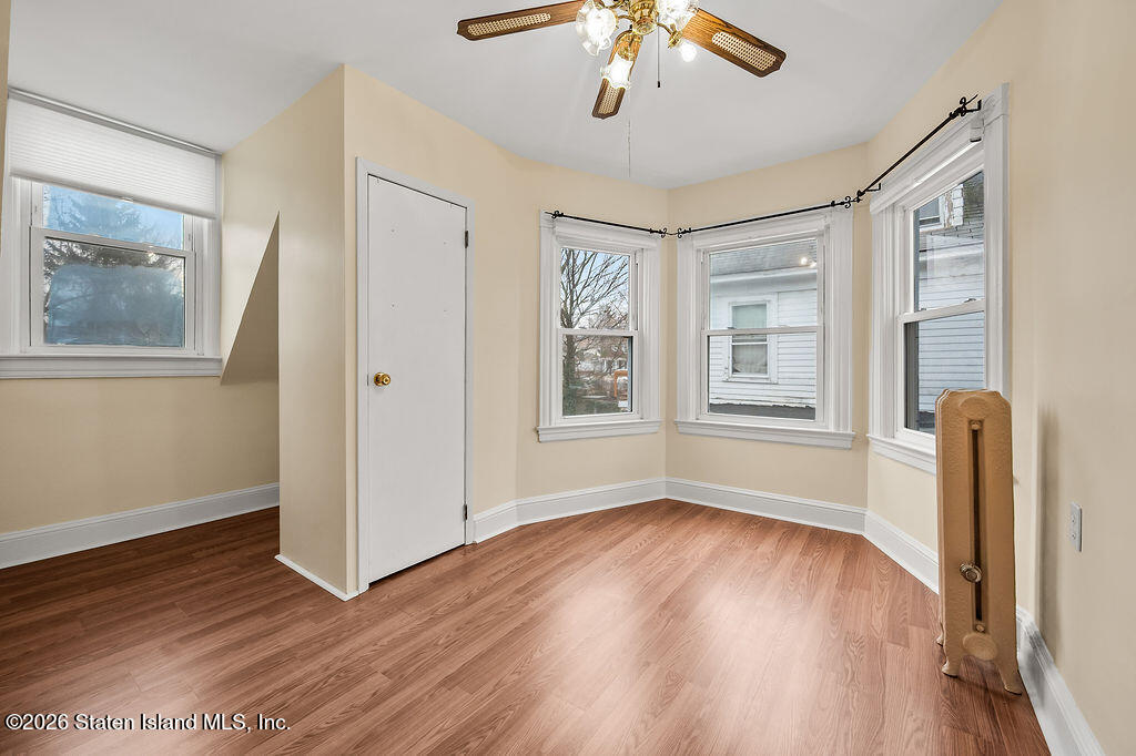 5272 Arthur Kill Road Staten Island, NY 10307 - Photo 19 of 32 a view of an empty room with a window and wooden floor