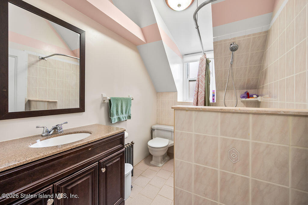 5272 Arthur Kill Road Staten Island, NY 10307 - Photo 20 of 32 a bathroom with a sink a toilet and a mirror