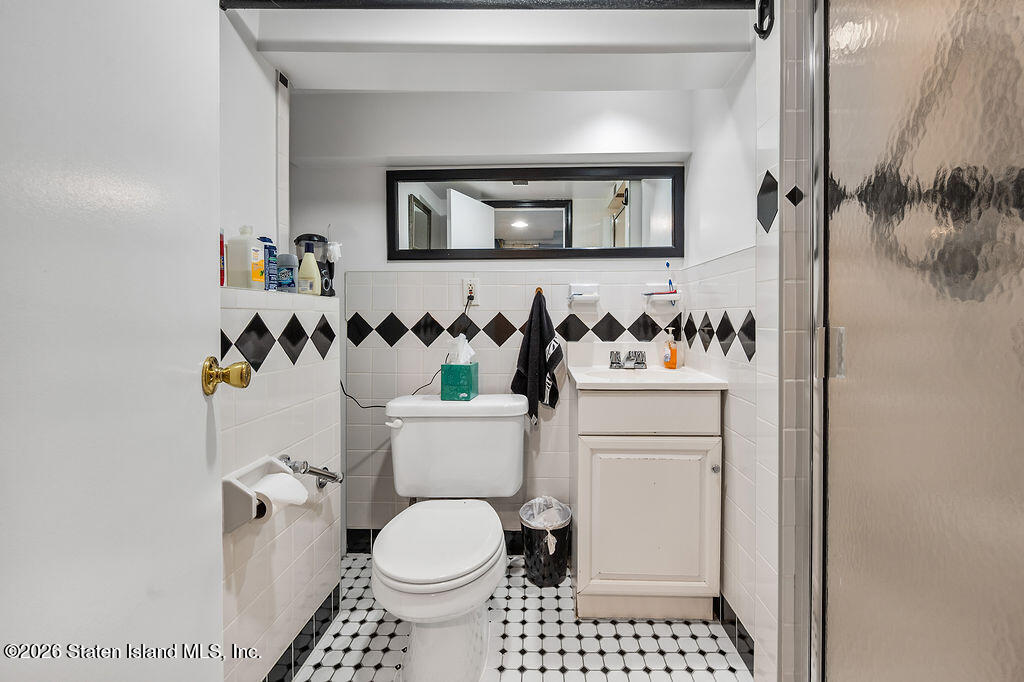5272 Arthur Kill Road Staten Island, NY 10307 - Photo 26 of 32 a bathroom with a toilet sink and mirror
