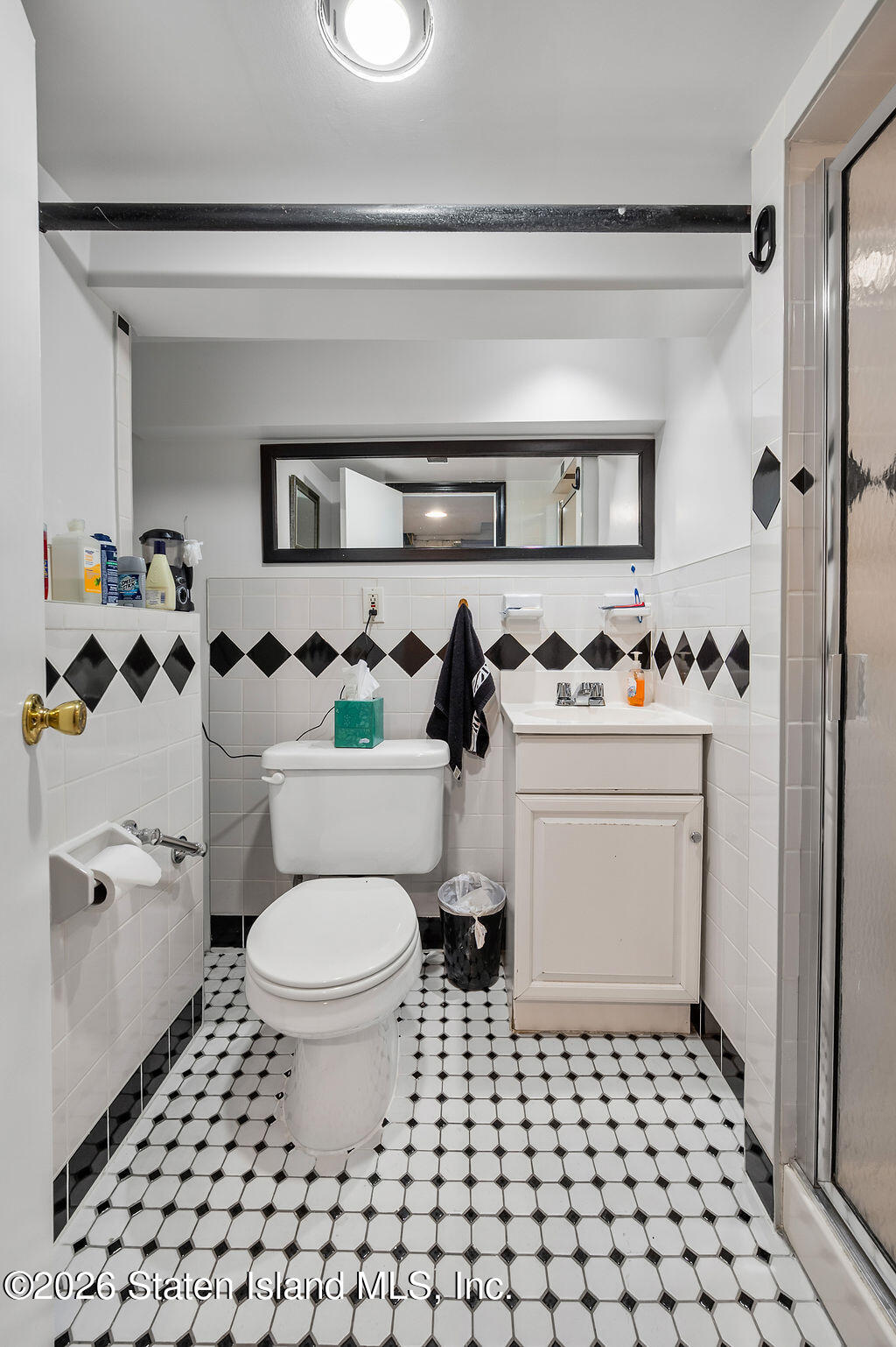 5272 Arthur Kill Road Staten Island, NY 10307 - Photo 27 of 32 a bathroom with a sink a toilet and a shower curtain